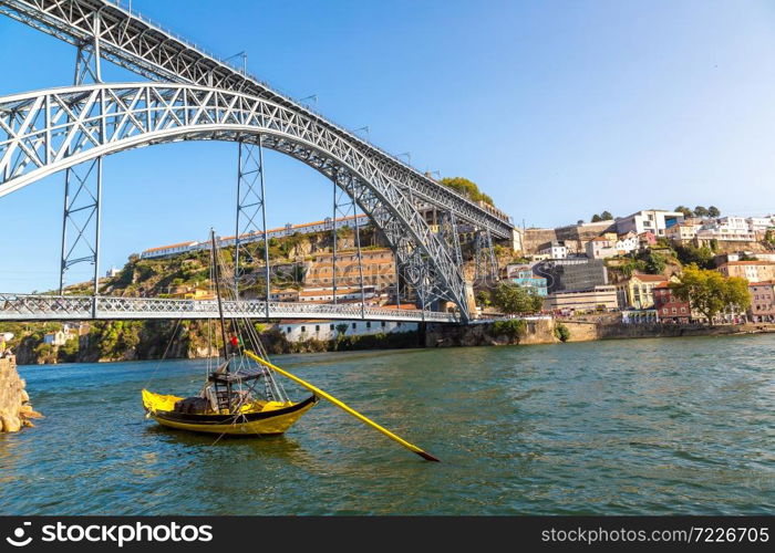 Traditional boats with wine barrels and Douro River in Porto in a beautiful summer day, Portugal