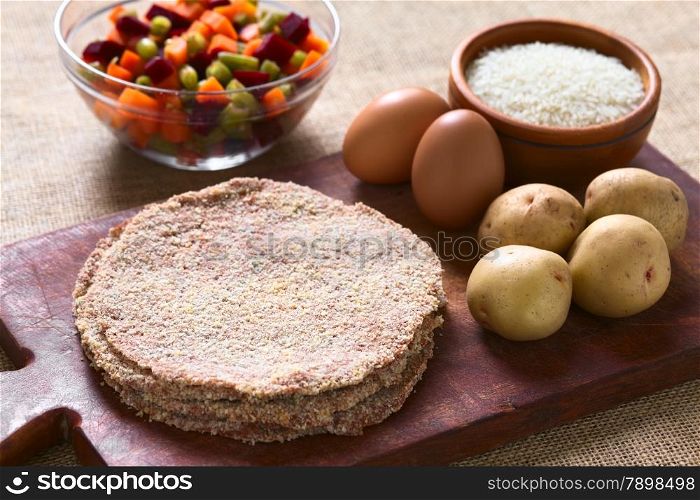 Traditional Bolivian meat called Silpancho, which is a breaded flat, round piece of beef meat, served with fried egg, rice, fried potatoes and vegetables (carrot, bean, beetroot), photographed with natural light (Selective Focus, Focus one third into the meat)