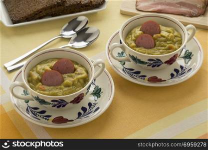 Traditional bowls with Dutch pea soup, bacon and rye bread. Traditional bowls with Dutch pea soup