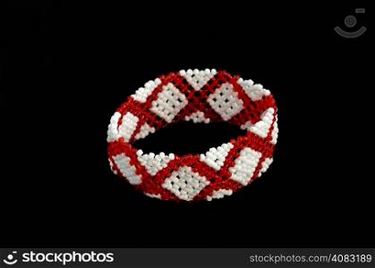 Traditional bulgarian adornment for forearm from white and red bead.