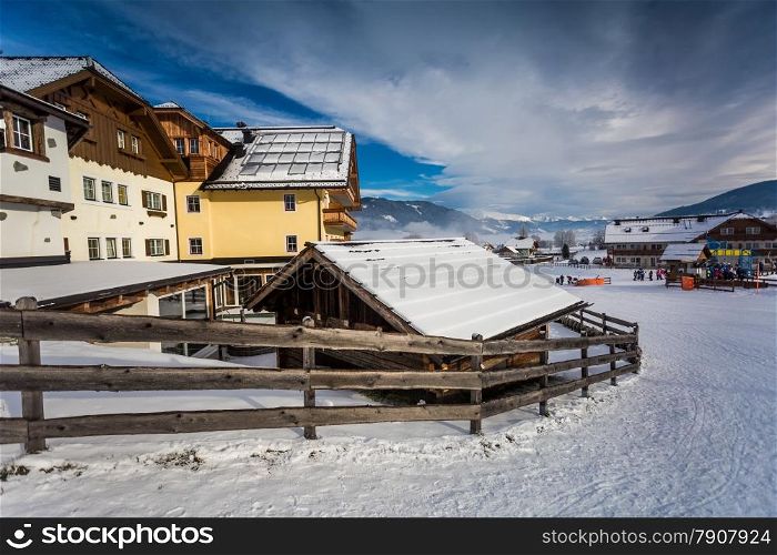 Traditional chalet and ski resort in Austrian Alps covered by snow