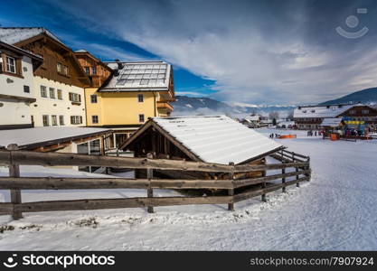 Traditional chalet and ski resort in Austrian Alps covered by snow