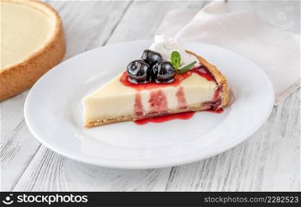 Traditional cheesecake wedge with amarena cherries on the plate