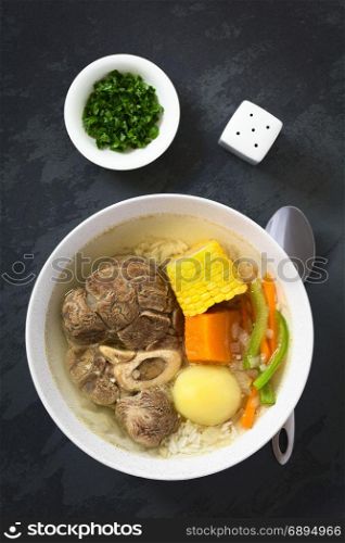 Traditional Chilean Cazuela de Vacuno or Cazuela de Carne, a beef soup with potato, corn, pumpkin, carrot, bell pepper, onion and rice, photographed overhead on slate with natural light. Chilean Cazuela de Vacuno or Carne, Beef Soup