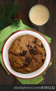 Traditional Chilean Pan de Pascua Christmas Cake made with spices, dried fruits and raisins, with a glass of Chilean Cola de Mono Christmas cocktail, photographed overhead with natural light (Selective Focus, Focus on the top of the cake)