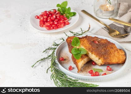 Traditional Christmas Rabanadas with lemon zest, pomegranate, pine nuts and cinnamon. Spanish Torrijas or french toasts close up on the countertop