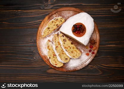 Traditional Christmas stollen cake with marzipan and dried fruit isolated on wooden background. High quality photo. Traditional Christmas stollen cake with marzipan and dried fruit isolated on wooden background