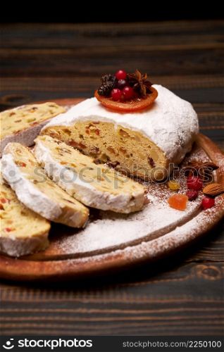 Traditional Christmas stollen cake with marzipan and dried fruit isolated on wooden background. High quality photo. Traditional Christmas stollen cake with marzipan and dried fruit isolated on wooden background