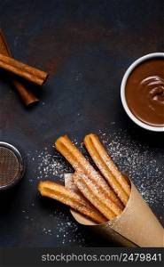 Traditional chrurro sticks hot with chocolate sausce and cinnamon flat lay copy space