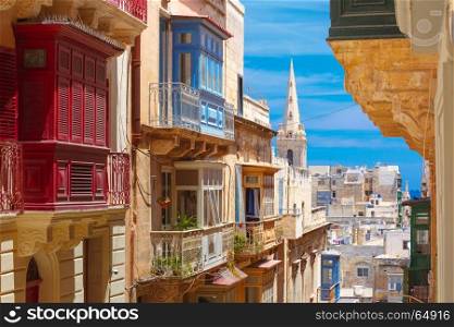 Traditional colorful wooden balconies, Malta. The traditional Maltese colorful wooden balconies and St. Paul's Anglican Pro-Cathedral in Valletta, Malta