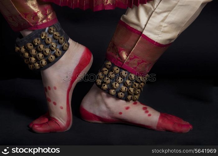 Traditional dancer&rsquo;s feet performing Bharatanatyam against black background