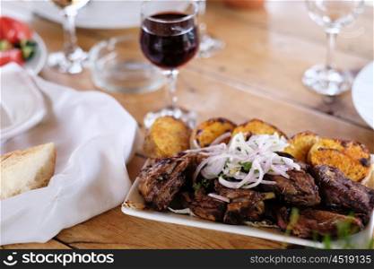 Traditional delicious kebab with onion and glass of wine
