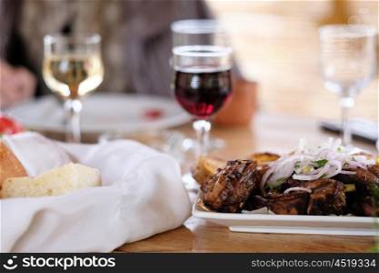 Traditional delicious kebab with onion and glass of wine
