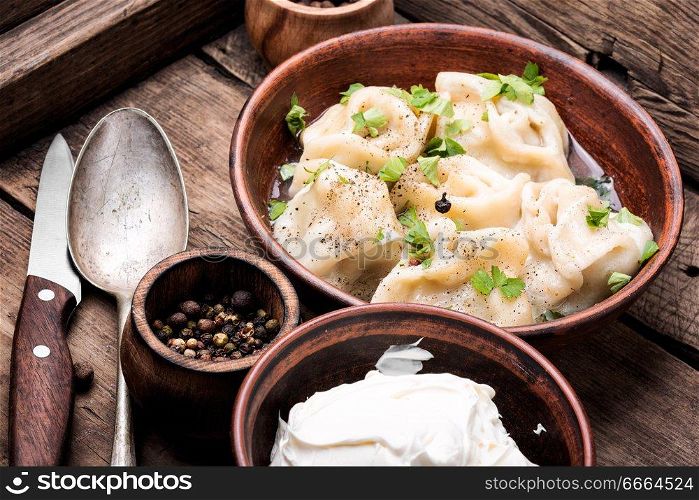 Traditional dish pelmeni.Meat dumplings on wooden rustic background.Russian food. Homemade meat dumplings
