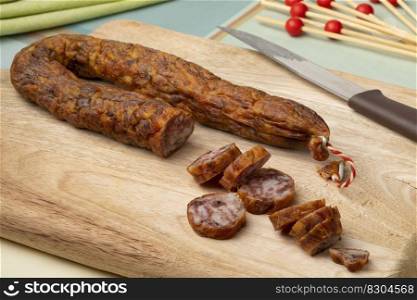 Traditional Dutch dried mature sausage, boerenmetworst, and slices close up on a cutting board