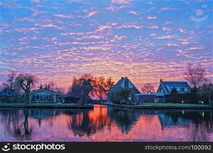 Traditional dutch houses in the countryside from the Netherlands at sunset