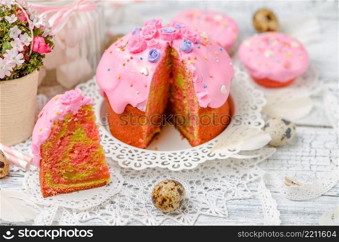 Traditional Easter cake with decorations and cupcakes on wooden table. Traditional Easter cake and cupcakes