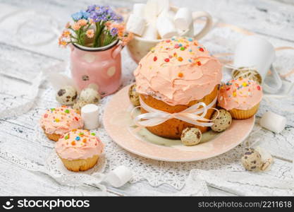 Traditional Easter cake with decorations and cupcakes on wooden table. Traditional Easter cake and cupcakes