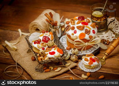 Traditional Easter cake with decorations and cupcakes on wooden table. Traditional Easter cake and cupcakes