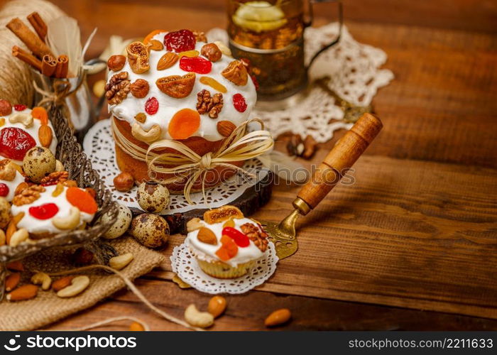 Traditional Easter cake with decorations and cupcakes on wooden table. Traditional Easter cake and cupcakes