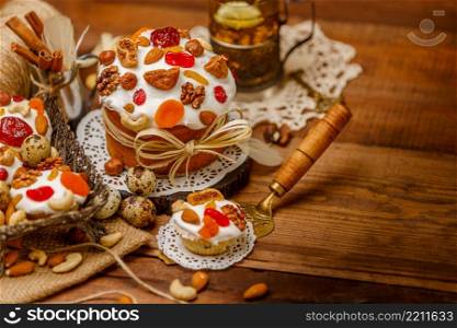Traditional Easter cake with decorations and cupcakes on wooden table. Traditional Easter cake and cupcakes