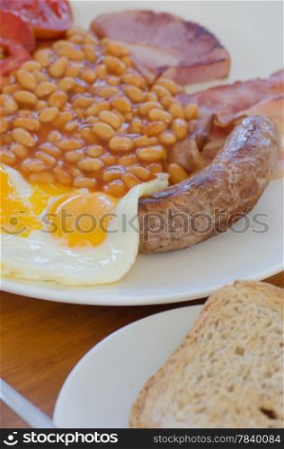 Traditional English breakfast - egg, beans , toast, sausage and bacon,