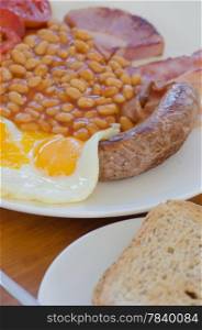 Traditional English breakfast - egg, beans , toast, sausage and bacon,