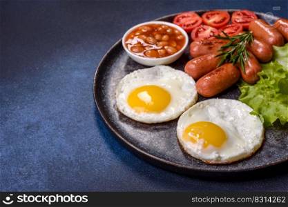 Traditional English breakfast with eggs, toast, sausages, beans, spices and herbs on a grey ceramic plate against a dark concrete background. Traditional English breakfast with eggs, toast, sausages, beans, spices and herbs on a grey ceramic plate