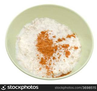 traditional english oat porridge with cinnamon in yellow bowl isolated on white background