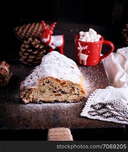 traditional European cake Stollen with nuts and candied fruit dusted with icing sugar