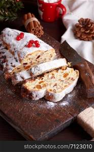 traditional European Stollen cake with nuts and candied fruit on a wooden board