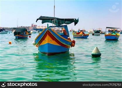 Traditional eyed colorful boats Luzzu in the Harbor of Mediterranean fishing village Marsaxlokk, Malta. Taditional eyed boats Luzzu in Marsaxlokk, Malta