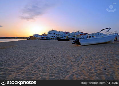 Traditional fisherman boat on the beach in Armacao de Pera at sunset