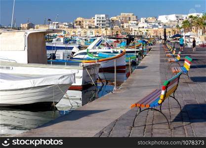Traditional fishing boats called Luzzu in the bay of the village Marsaxlokk. Malta.. Marsaxlokk. Traditional boats Luzzu in the old harbor.