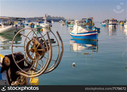 Traditional fishing boats called Luzzu in the bay of the village Marsaxlokk. Malta.. Marsaxlokk. Traditional boats Luzzu in the old harbor.