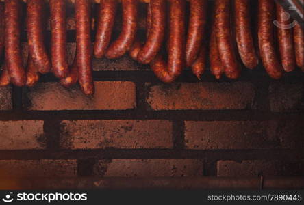 Traditional food. Smoked sausages meat hanging in domestic smokehouse.