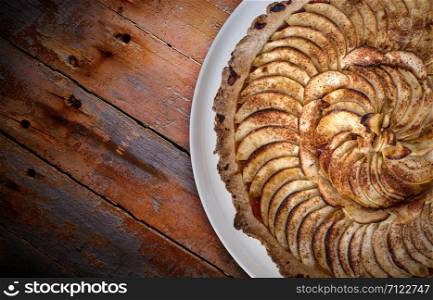 Traditional french apple tart over brown planks background. Traditional french apple tart over brown planks