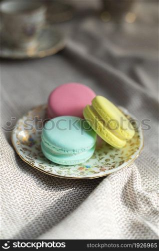 traditional french colorful macarons cookies stand on wooden table,pastel colors macaroons for afternoon tea or coffee copy space. traditional french colorful macarons cookies stand on wooden table,pastel colors macaroons for afternoon tea or coffee