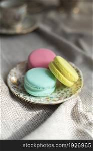 traditional french colorful macarons cookies stand on wooden table,pastel colors macaroons for afternoon tea or coffee copy space. traditional french colorful macarons cookies stand on wooden table,pastel colors macaroons for afternoon tea or coffee