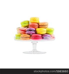 traditional french colorful macarons in a glass cake stand on white background