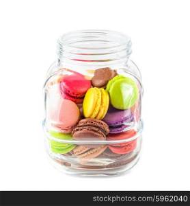 traditional french colorful macarons in a glass jar on white background