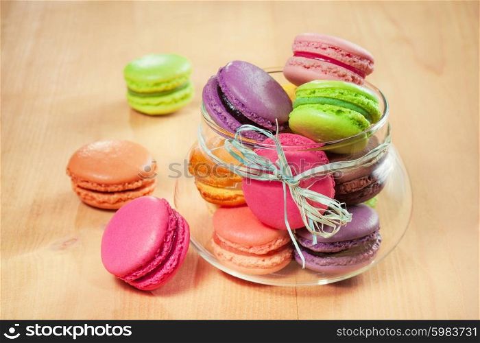 traditional french colorful macarons in a glass on wooden table