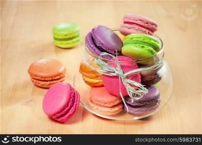 traditional french colorful macarons in a glass on wooden table
