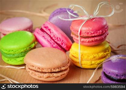 traditional french colorful macarons with a bow on wooden table