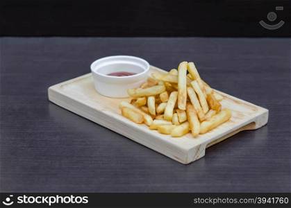 Traditional French fries . Traditional French fries on wooden plate with tomato sauce