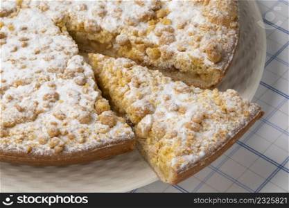 Traditional fresh baked Dutch Apple crumble cake and a piece close up