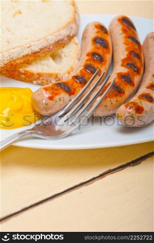 traditional fresh German wurstel sausages grilled with yellow mustard