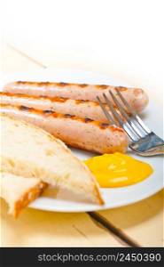traditional fresh German wurstel sausages grilled with yellow mustard 