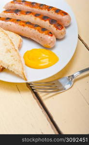 traditional fresh German wurstel sausages grilled with yellow mustard