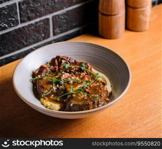 Traditional german braised veal cheeks in brown sauce with mashed potatoes